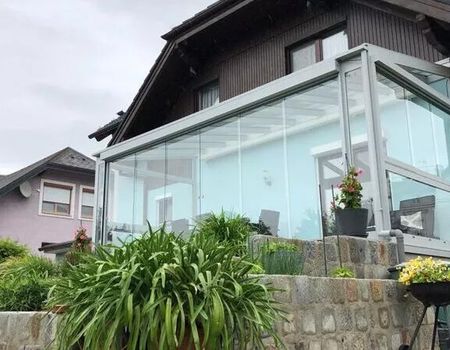 Eine Terrasse mit Sommergarten mit einer Senkrechtmarkise
