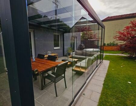 Eine Terrassenüberdachung mit Esstisch und Stühlen