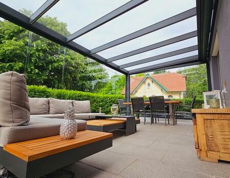 Eine Terrassenüberdachung mit Esstisch und Stühlen