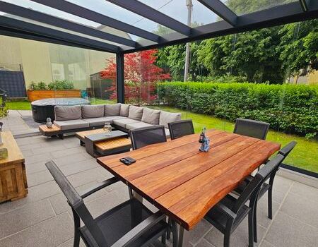 Eine Terrassenüberdachung mit Esstisch und Stühlen