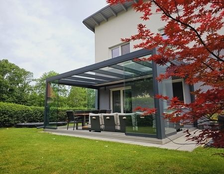 Eine Terrassenüberdachung mit Esstisch und Stühlen