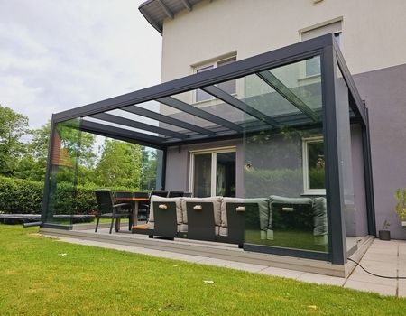 Ein Sommergarten in anthrazit mit Glasschiebetüren auf einer großen Terrasse