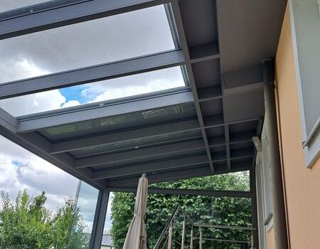 Ein großer Sommergarten mit Dachrollladen als Beschattung sowie Glasschiebetüren rundum