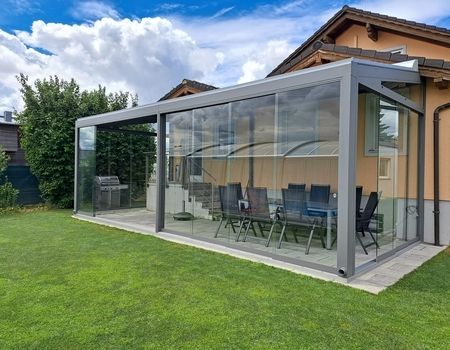 Ein großer Sommergarten mit Dachrollladen als Beschattung sowie Glasschiebetüren rundum