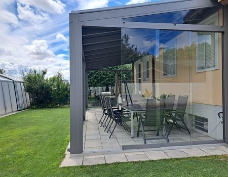 Ein großer Sommergarten mit Dachrollladen als Beschattung sowie Glasschiebetüren rundum