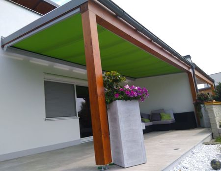 Eine Terrassenüberdachung mit einer grünen Unterglas-Markise