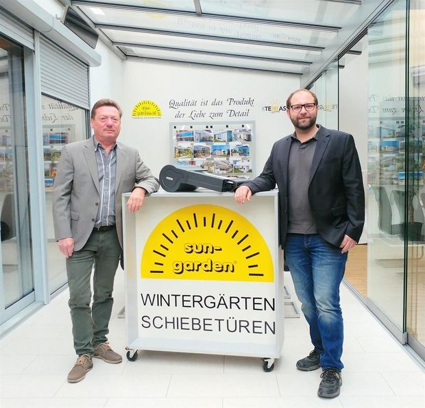 Firmengründer links und recht vor dem alten Firmenlogo