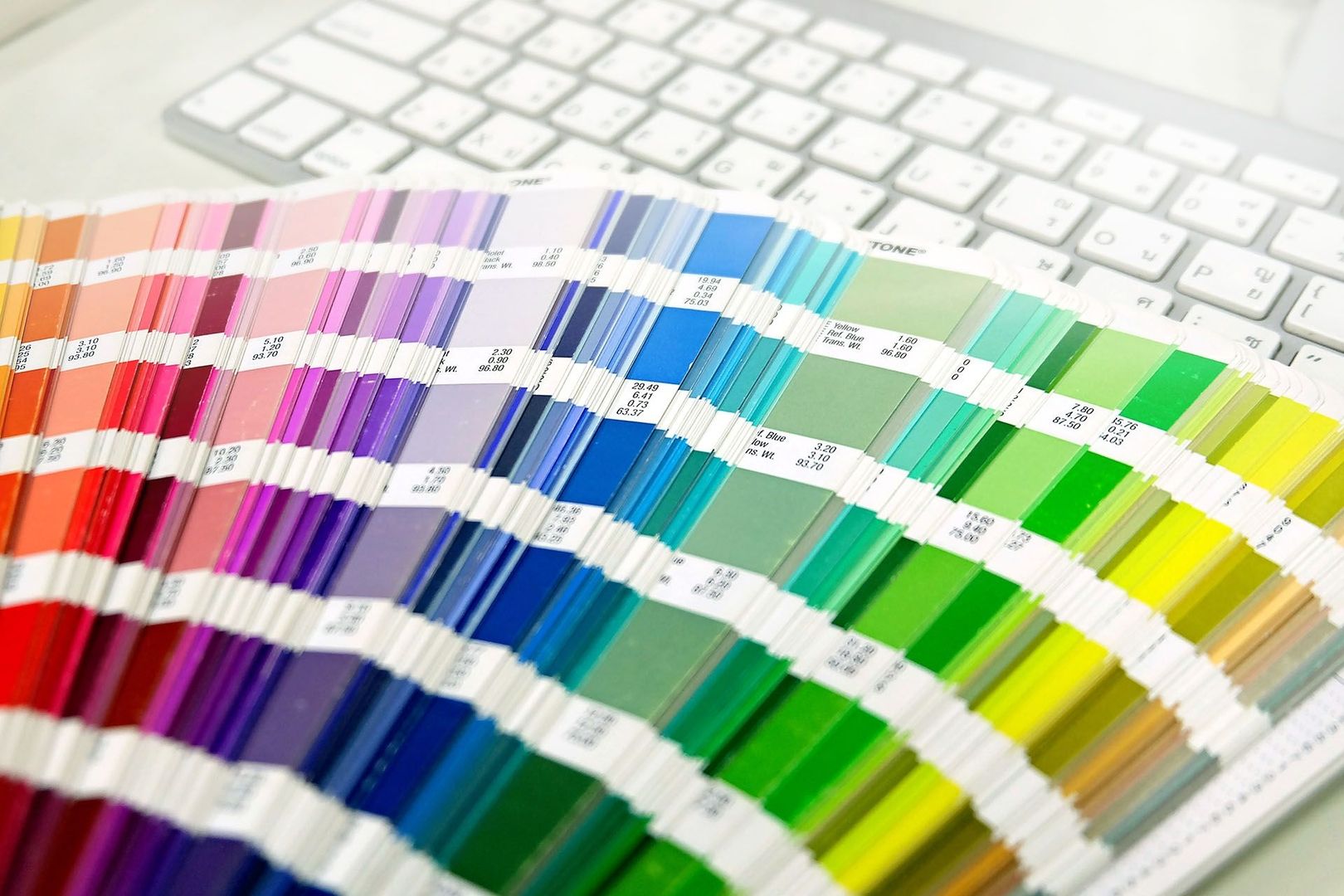 Viele Farbbeispiele liegen auf einem Schreibtisch