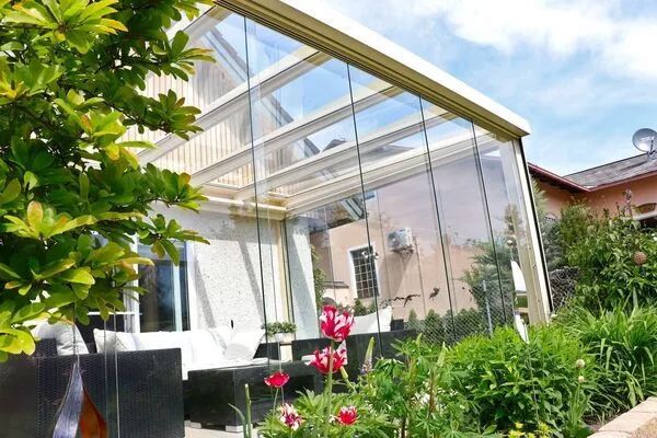 Ein Sommergarten in weiß mit Glasschiebetüren