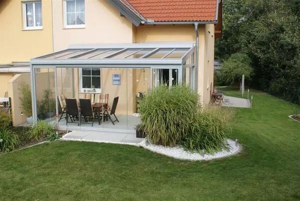 Eine Terrasse mit einem Sommergarten und Glasschiebetüren