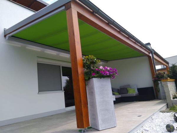 Eine Terrassenüberdachung mit einer grünen Unterglas-Markise